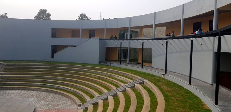 Stepped amphitheatre seating below the curved two-storey building and its balcony