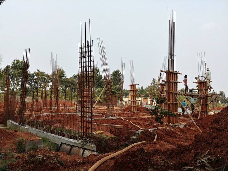 Column reinforcement and formwork rising across a construction site