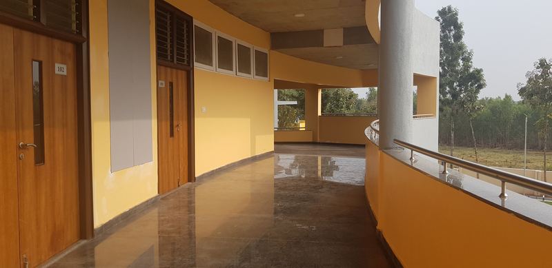 Corridor with polished stone flooring, timber doors and a curved balcony