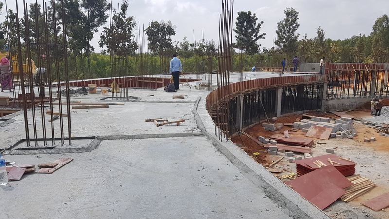 Concrete floor following the building's curve, column bars ready for the next storey