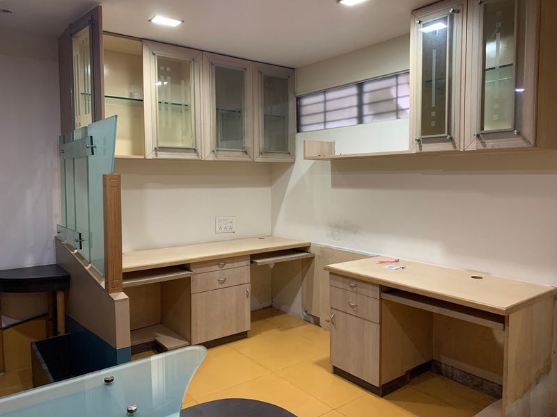 Office with built-in wooden workstations, glass-fronted cabinets and a glazed partition