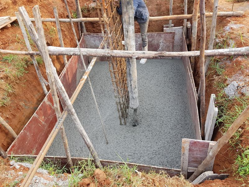Freshly poured concrete in a column footing with timber formwork